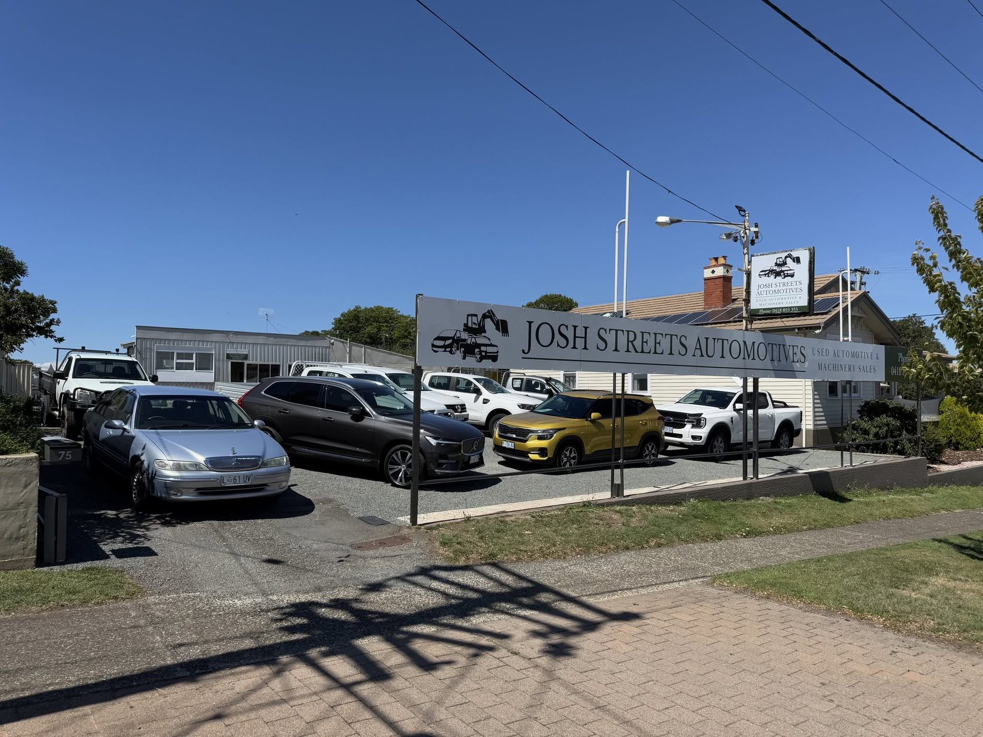Utes and SUVs parked under the Josh Streets Automotives sign in Deloraine